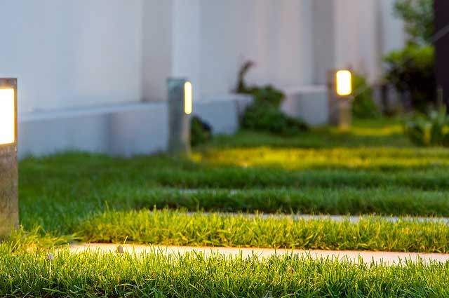 Outdoor landscape and yard lighting installation at dusk